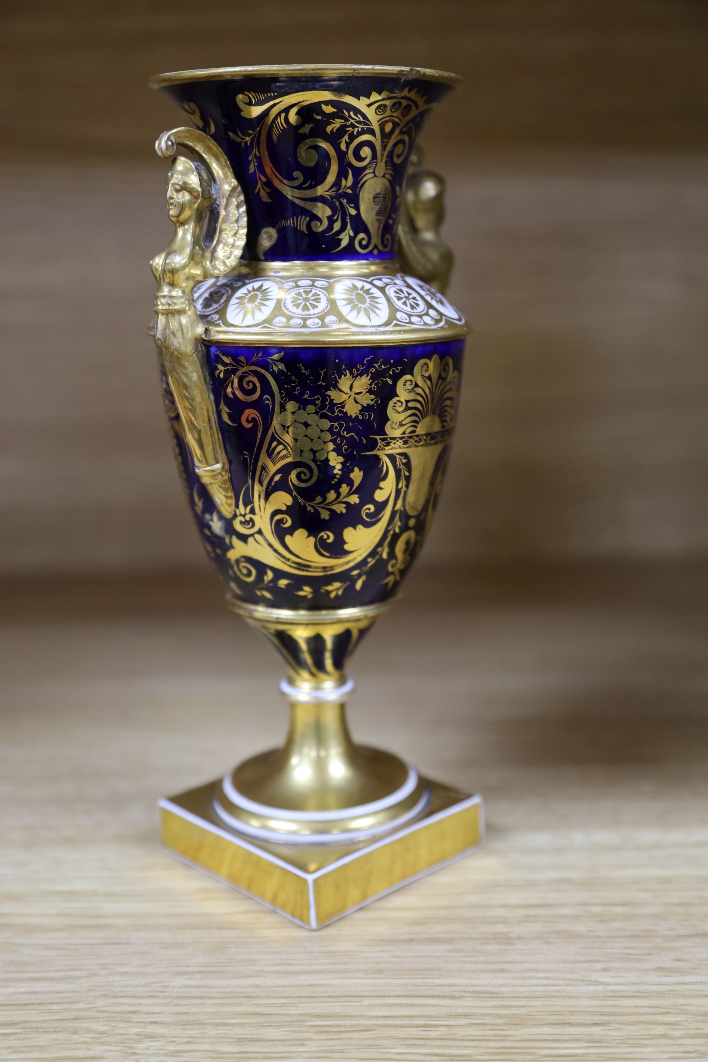 A garniture of three early 19th century English porcelain vases, c.1815-20, each painted with topographical views, tallest 26cm